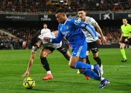 real madrid edge valencia to stay on barca s tail