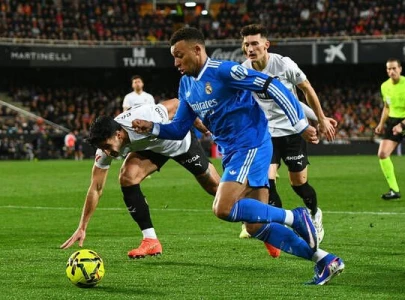real madrid edge valencia to stay on barca s tail