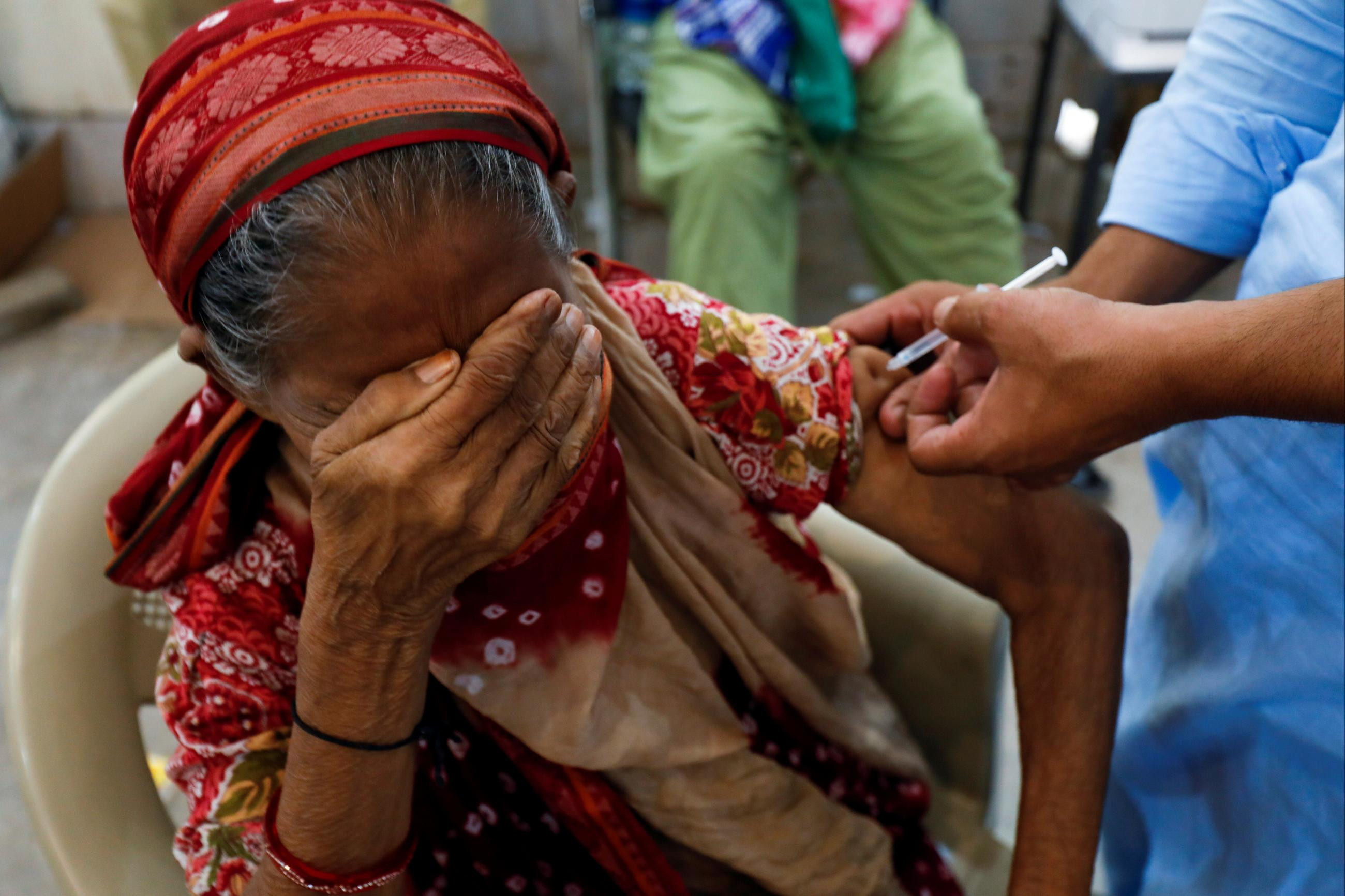 A woman, Basanti, 71, reacts as she receives a dose of the COVID-19 vaccine at a vaccination center in Karachi, Pakistan, on June 9, 2021. Photo: Reuters/Akhtar Soomro