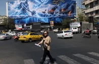 a woman walks past a billboard about the strait of hormuz on a building in tehran iran september 16 2026 photo reuters