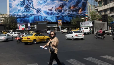 a woman walks past a billboard about the strait of hormuz on a building in tehran iran september 16 2026 photo reuters