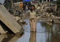 a woman covered in mud stands on a street filled with mud after a flash flood hit the area in aceh tamiang aceh province photo afp