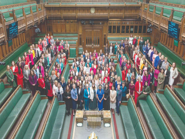 women mps pose together in the house of commons chamber for a group photo to celebrate international women s day in london photo afp