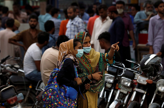 women wearing protective face masks talk outside a market as the coronavirus disease covid 19 pandemic continues in karachi photo reuters