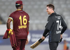 new zealand s mitchell santner r and west indies romario shepherd talk after the first twenty20 international cricket match at eden park in auckland on november 5 photo afp