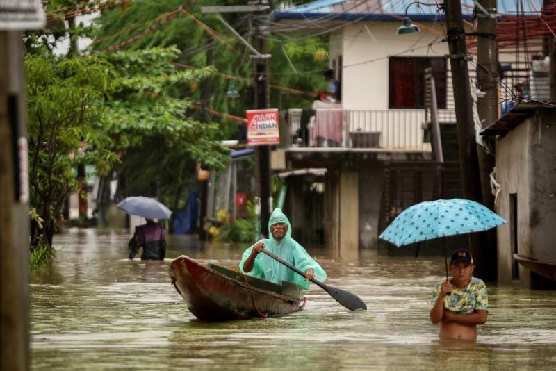 people wade through the floodwaters as it rains during tropical storm yagi locally known as enteng in apalit pampanga philippines september 5 2024 photo reuters