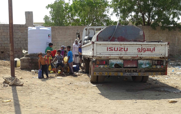 Yemeni families fill their jerricans with water on the outskirts of a camp for displaced people at the Khokha district of the western province of Hodeidah on December 11, 2018. PHOTO: AFP