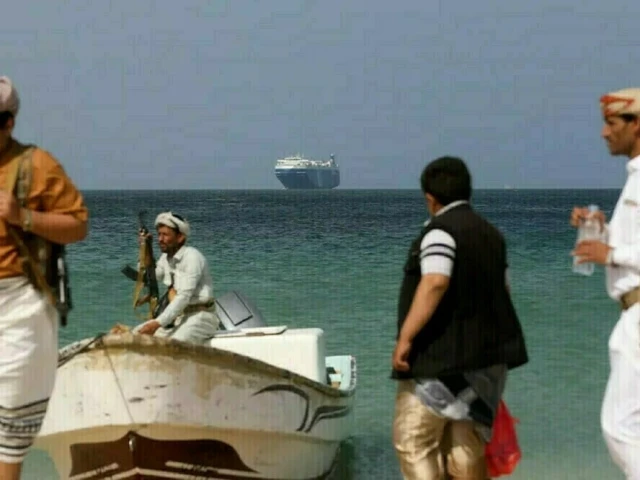 houthi fighters near red sea as a cargo vessel is in the background photo afp